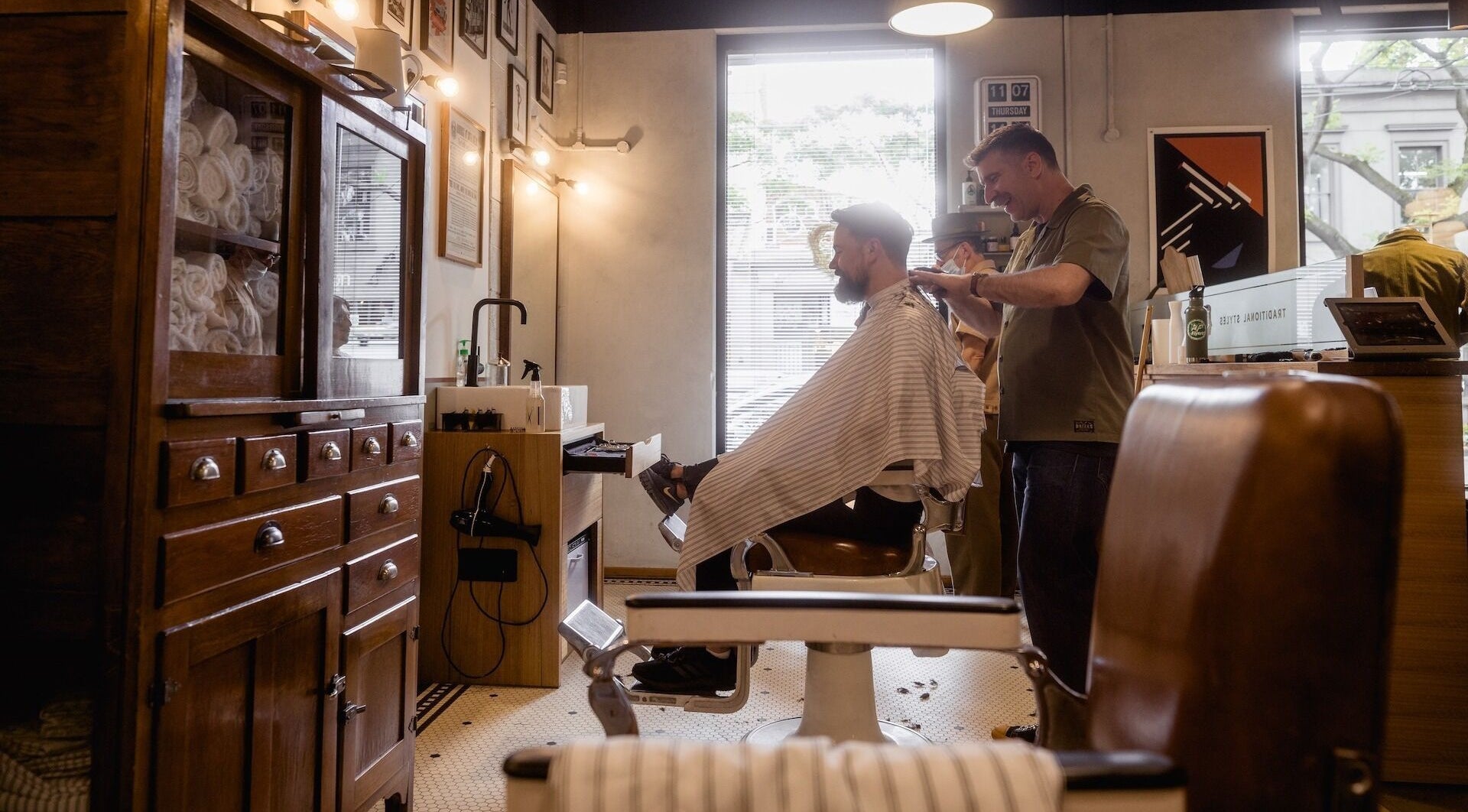 A barber styling hair at P&P Barbers — PPHH Store, Melbourne, Victoria, AU in a vintage-themed setting.