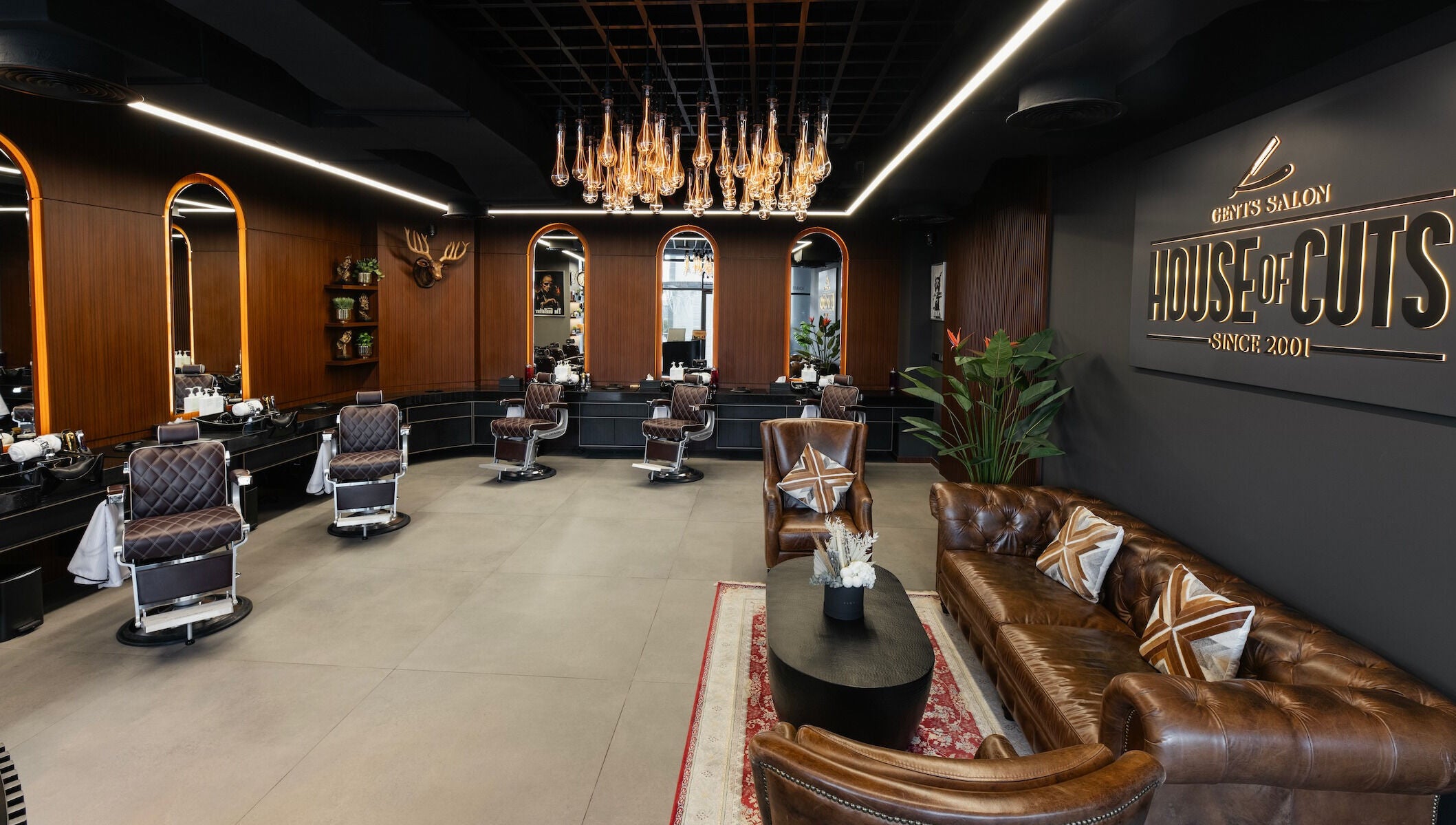 Chic interior of House of Cuts - Business Bay, Dubai, Dubai, AE featuring brown leather seating and vintage barber chairs.