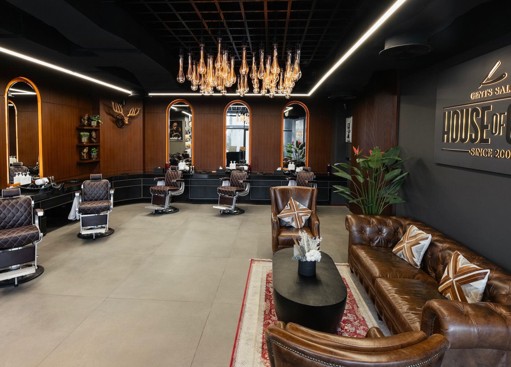 Chic interior of House of Cuts - Business Bay, Dubai, Dubai, AE featuring brown leather seating and vintage barber chairs.