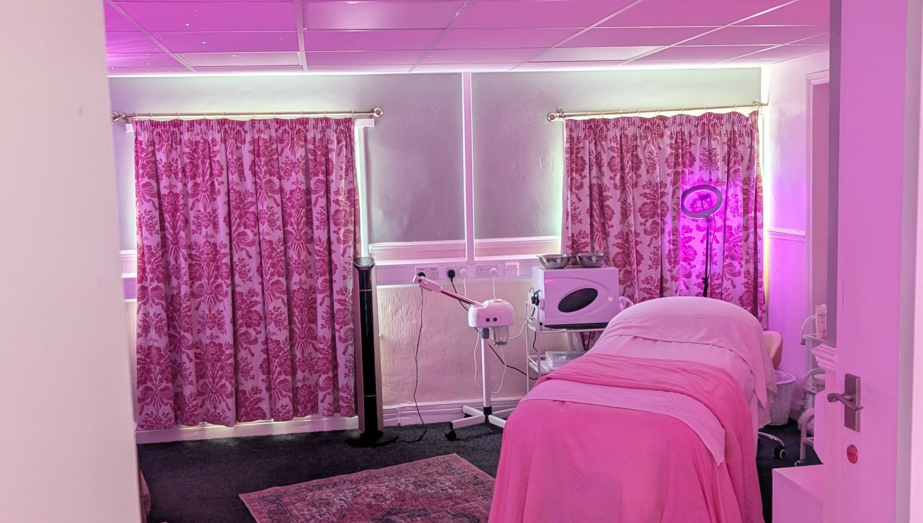 Cozy treatment room at Skinfit Studio, Shifnal, England, GB with pink decor and wellness equipment.