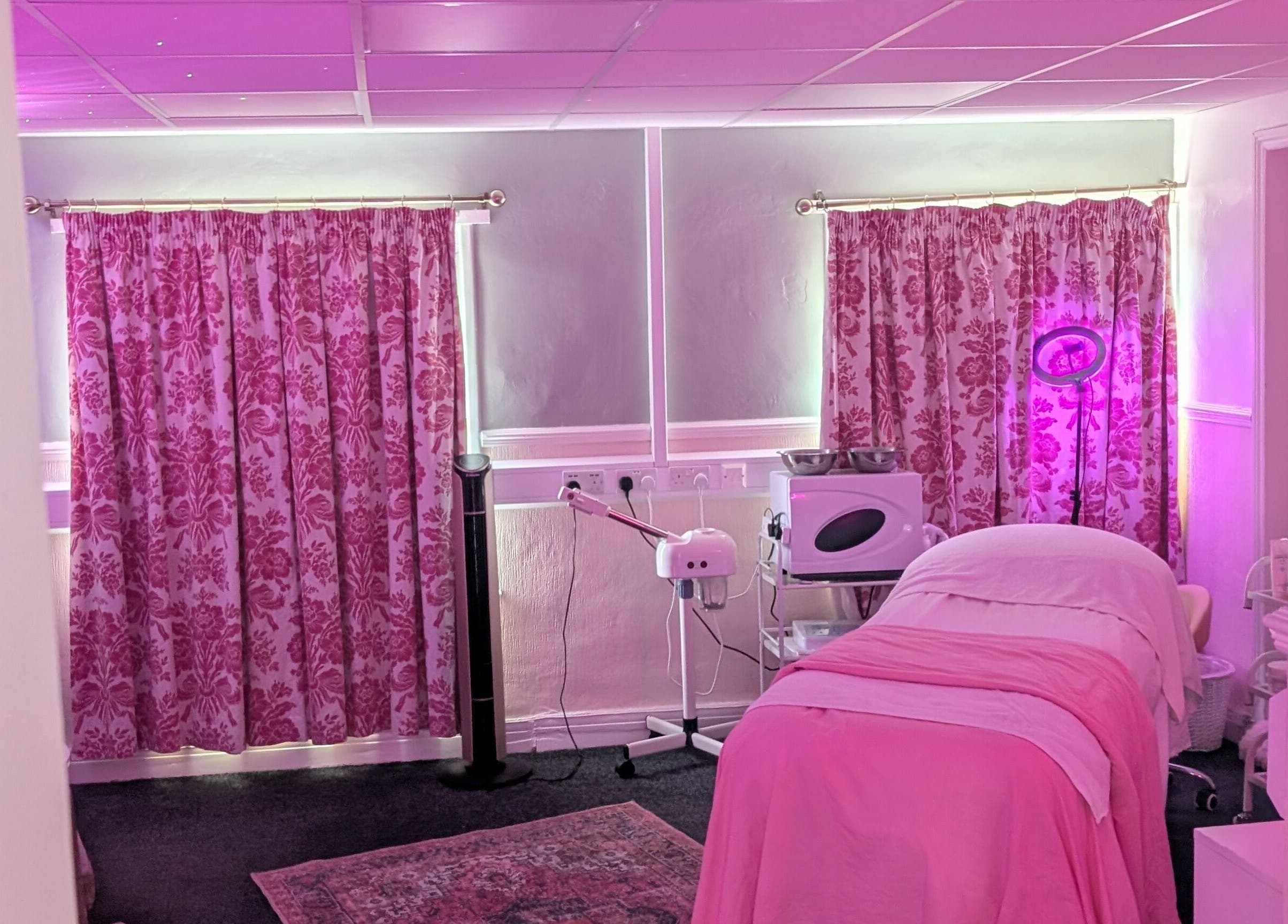 Cozy treatment room at Skinfit Studio, Shifnal, England, GB with pink decor and wellness equipment.