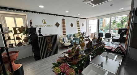 Interior of Bangkok Wellness, St. Julian's, MT, showcasing cozy seating with cultural decor and natural light.