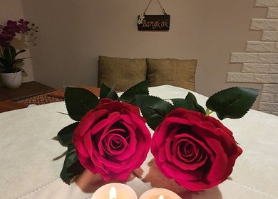 Two red roses and candles create a tranquil setting at Bangkok Wellness, St. Julian's, MT.