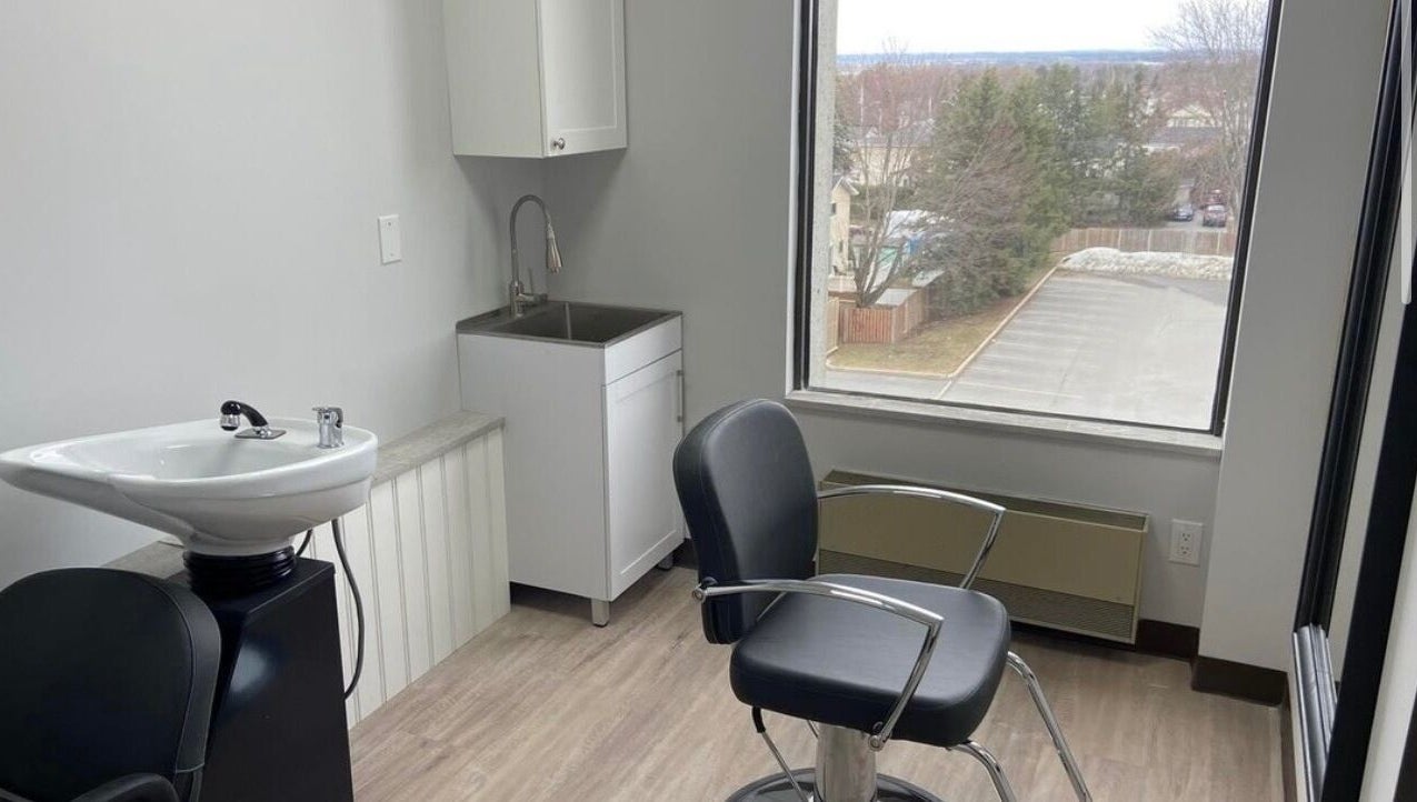 Elegant salon suite at Kurlessence, Ottawa, Ontario, CA, featuring a styling chair and basin with window view.