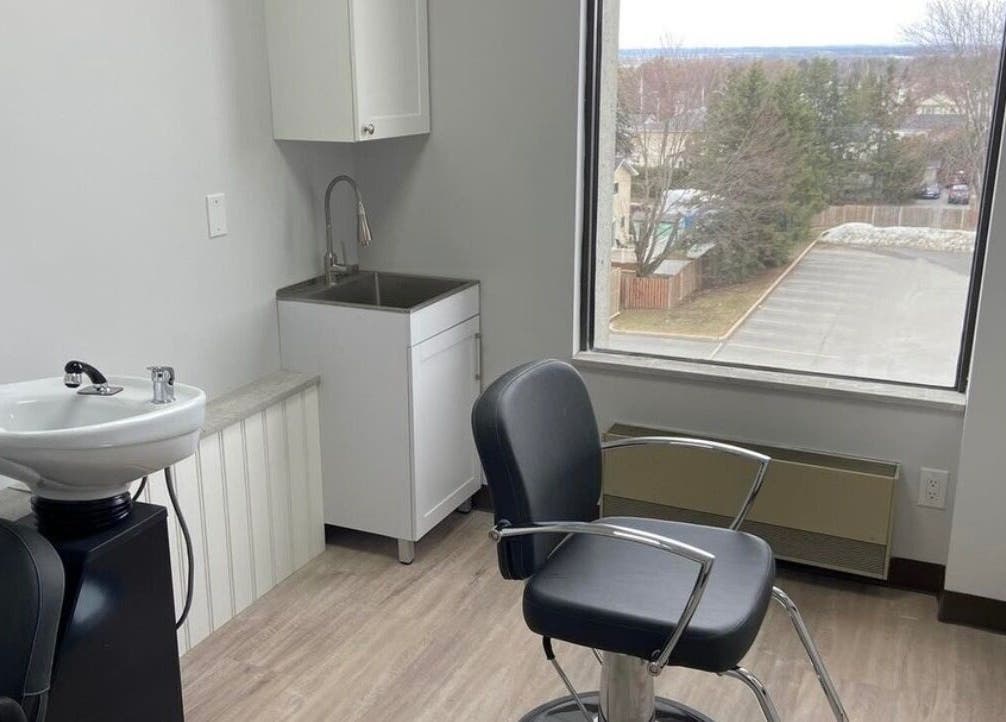 Elegant salon suite at Kurlessence, Ottawa, Ontario, CA, featuring a styling chair and basin with window view.