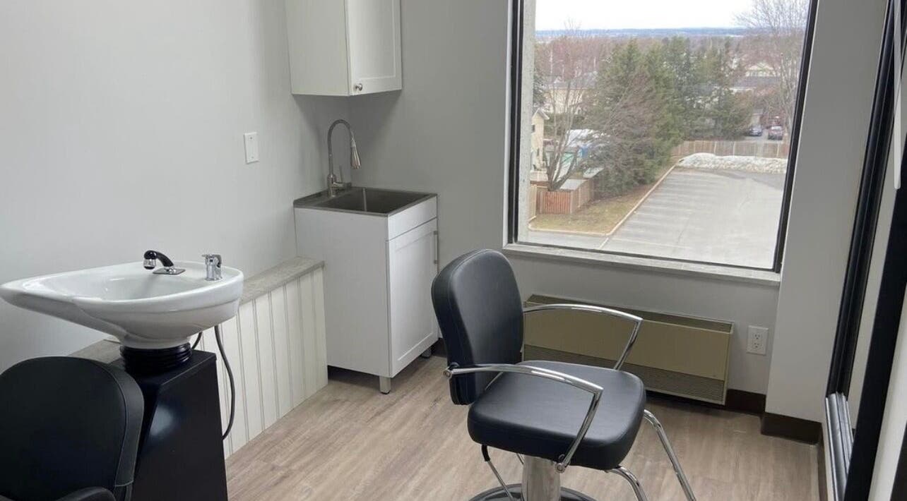 Elegant salon suite at Kurlessence, Ottawa, Ontario, CA, featuring a styling chair and basin with window view.