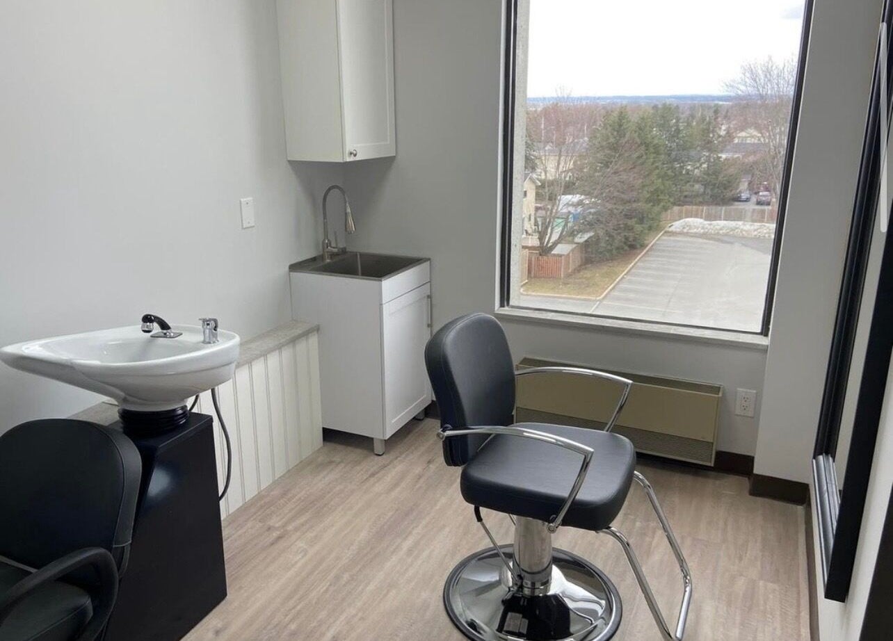 Interior of Kurlessence in Ottawa, Ontario, CA showcasing a modern salon chair and sink.
