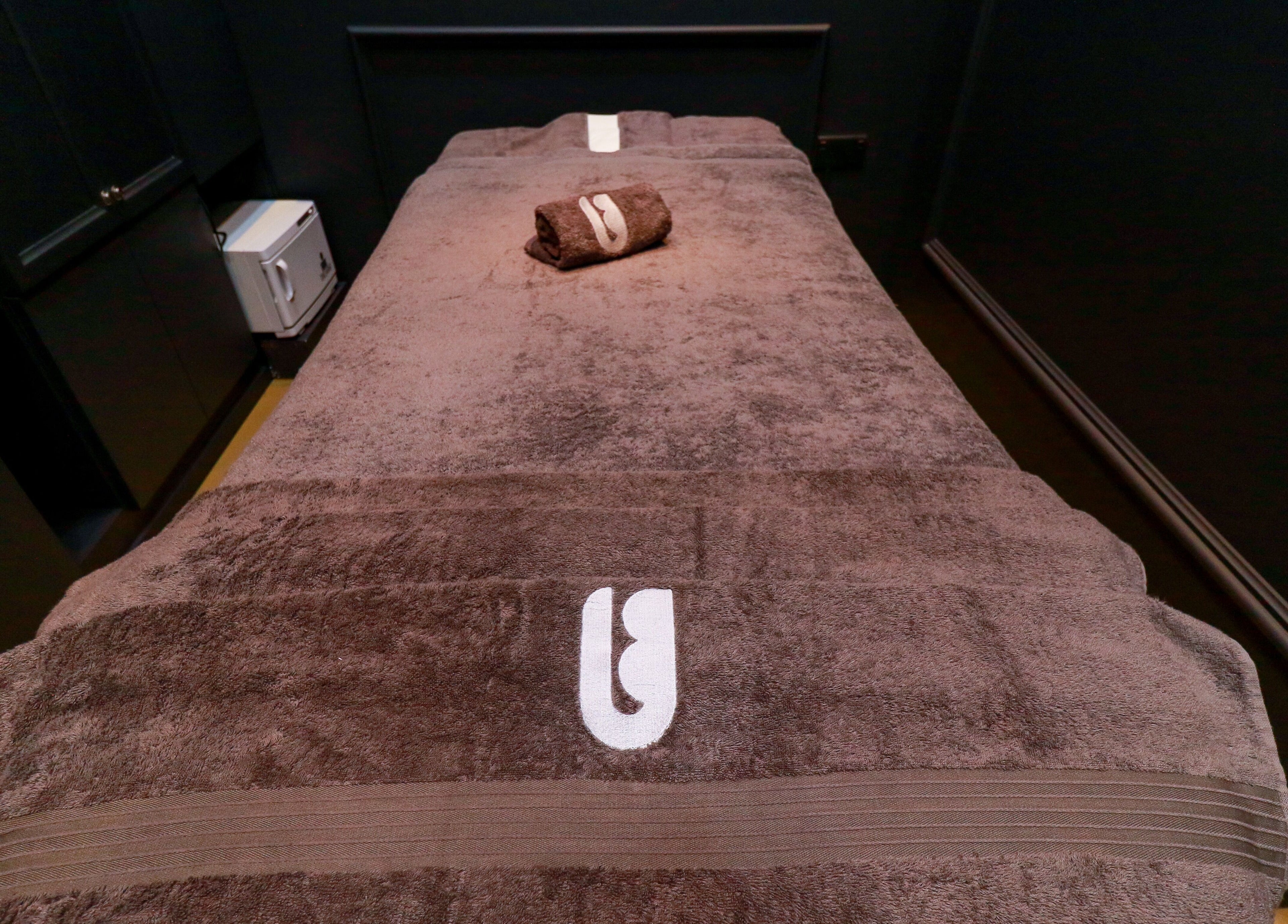 Luxurious massage table at UB Grooming Salon Ltd. DIFC, Dubai, AE, adorned with plush towels.