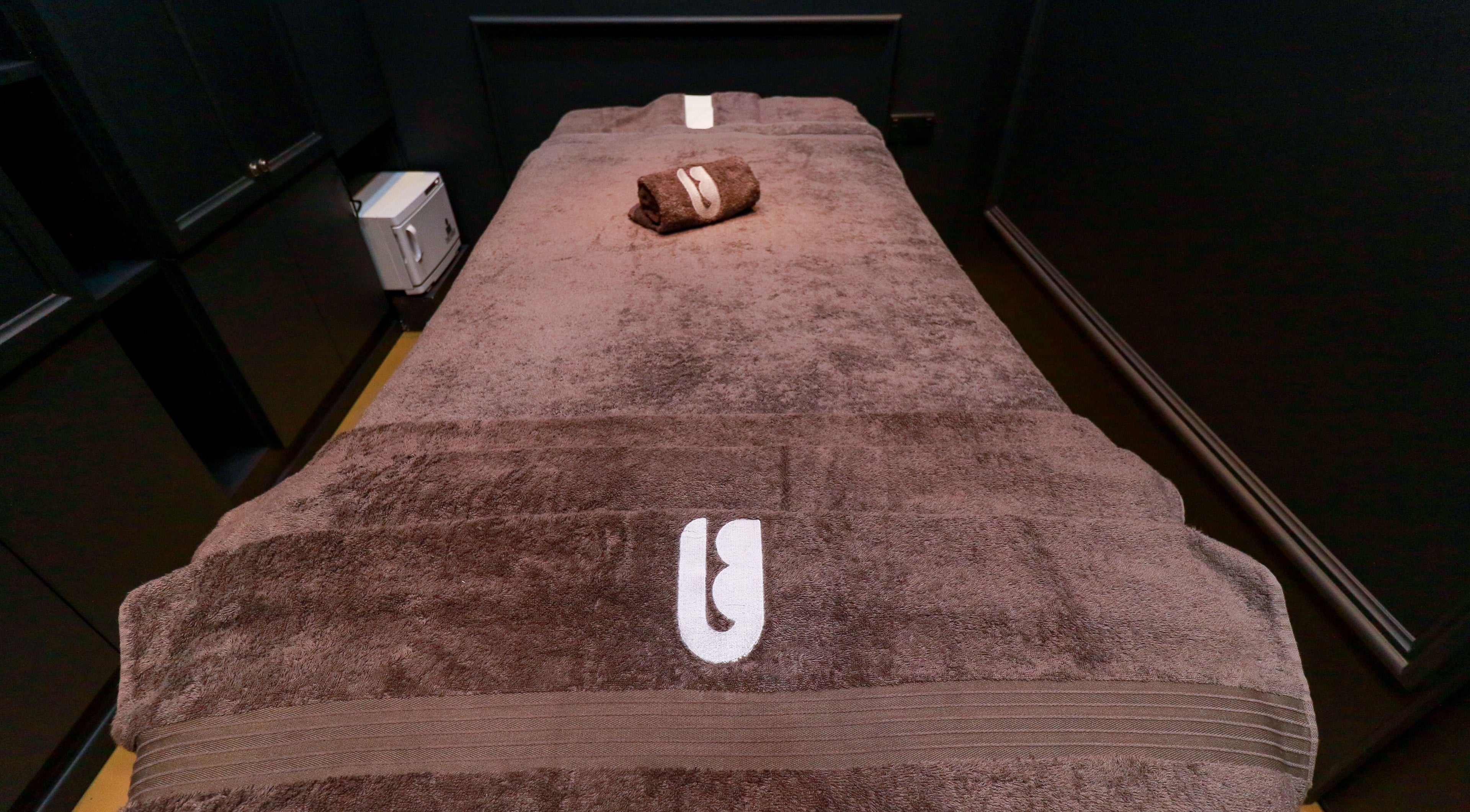 Luxurious massage table at UB Grooming Salon Ltd. DIFC, Dubai, AE, adorned with plush towels.