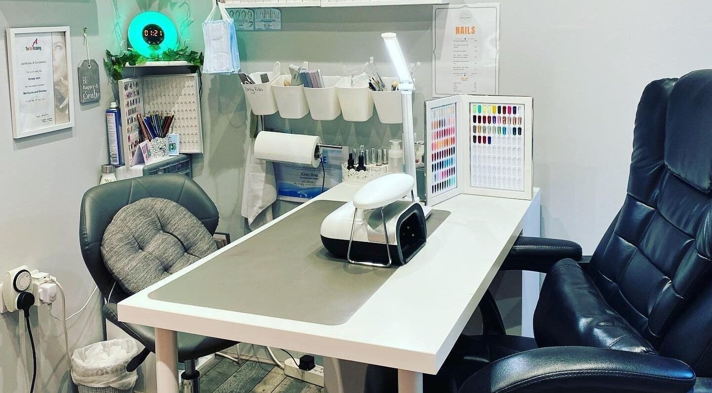 Modern nail station at Beauty and Bliss, Aylesbury, England, GB with sleek chairs and colorful nail polishes.