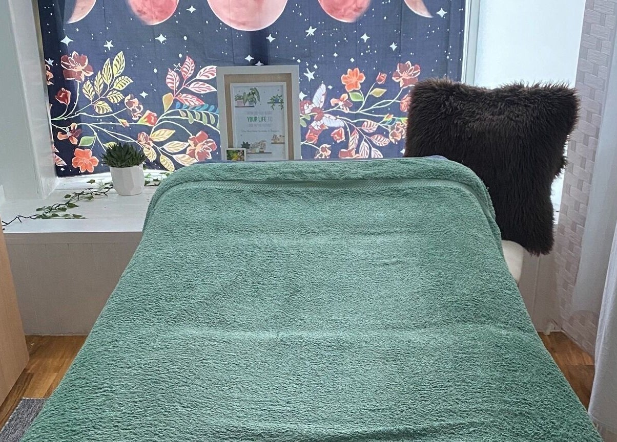 Cozy treatment room at Wonderland Wellbeing, North Shields, England, GB with green towel and decorative curtain.