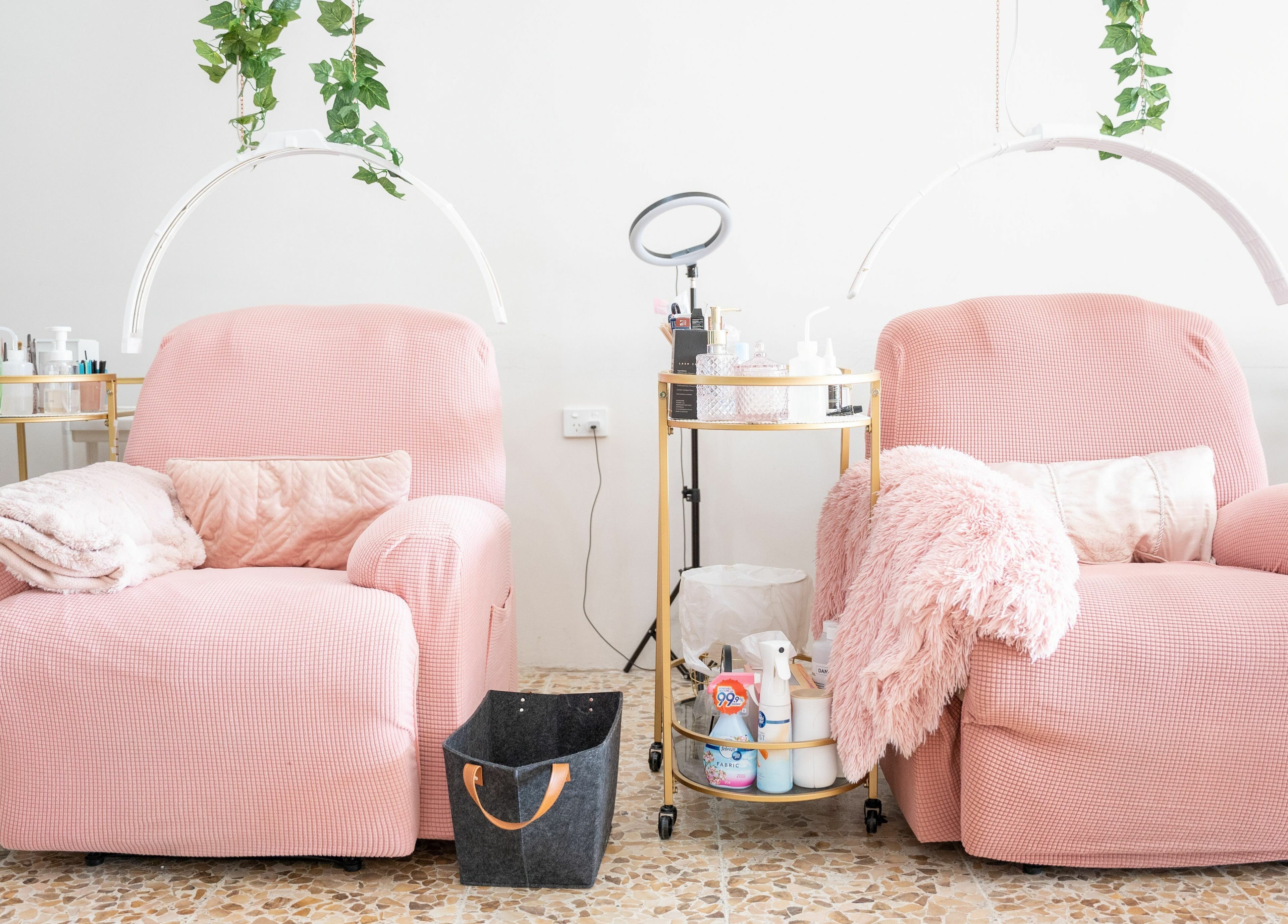 Comfortable pink seating at The Seven Great Lashes in Melbourne, Victoria, AU, with plush blankets and beauty tools.