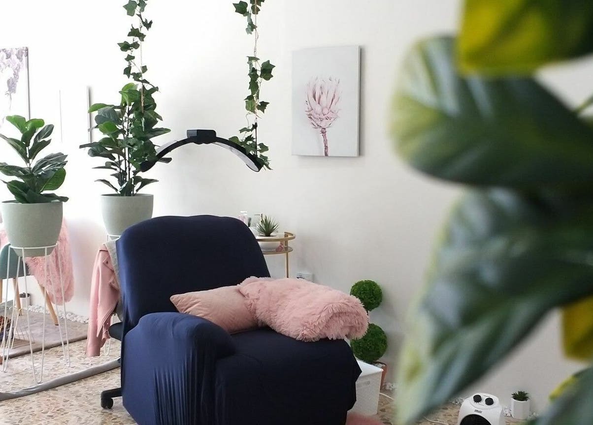 Relaxing lounge at The Seven Great Lashes, Melbourne, Victoria, AU with lush plants and cozy seating.