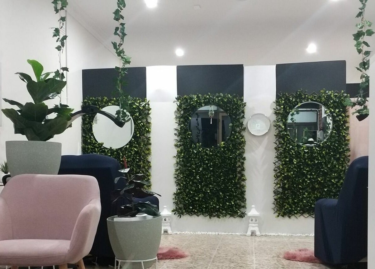 Greenery-filled salon area at The Seven Great Lashes in Melbourne, Victoria, AU with stylish seating.