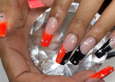Elegant nail art at Nail Couture Cave Creek, Cave Creek, Arizona, US, featuring red and black ombre with rhinestones.
