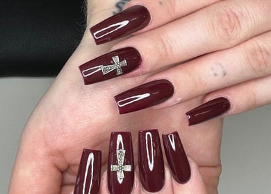 Elegant crimson nails with cross design at Nail Couture Cave Creek, Cave Creek, Arizona, US.