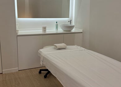 Sala de masaje en Teresa Arrieta, Lloret De Mar, Catalunya, ES, con cama blanca y lavabo moderno.