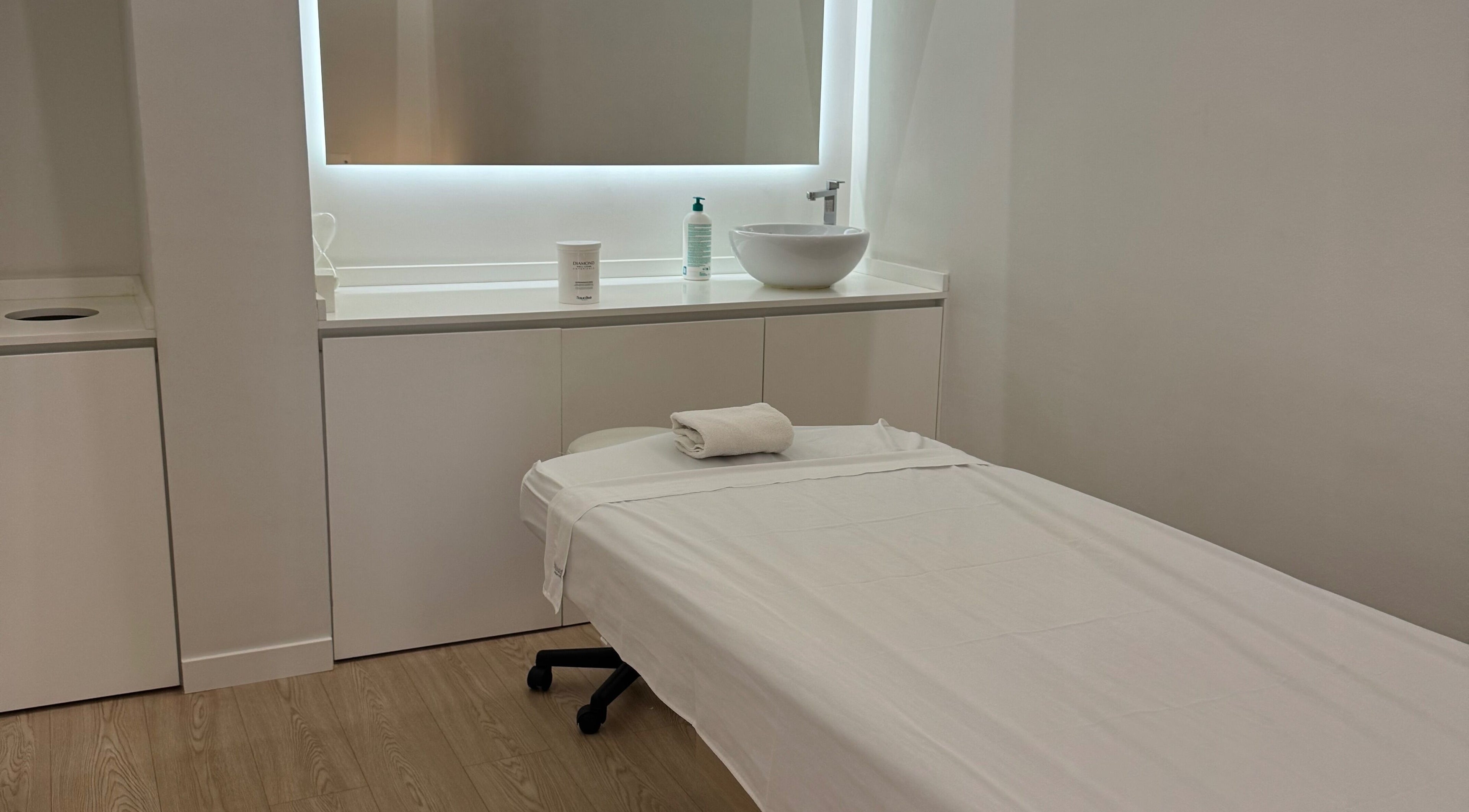 Sala de masaje en Teresa Arrieta, Lloret De Mar, Catalunya, ES, con cama blanca y lavabo moderno.