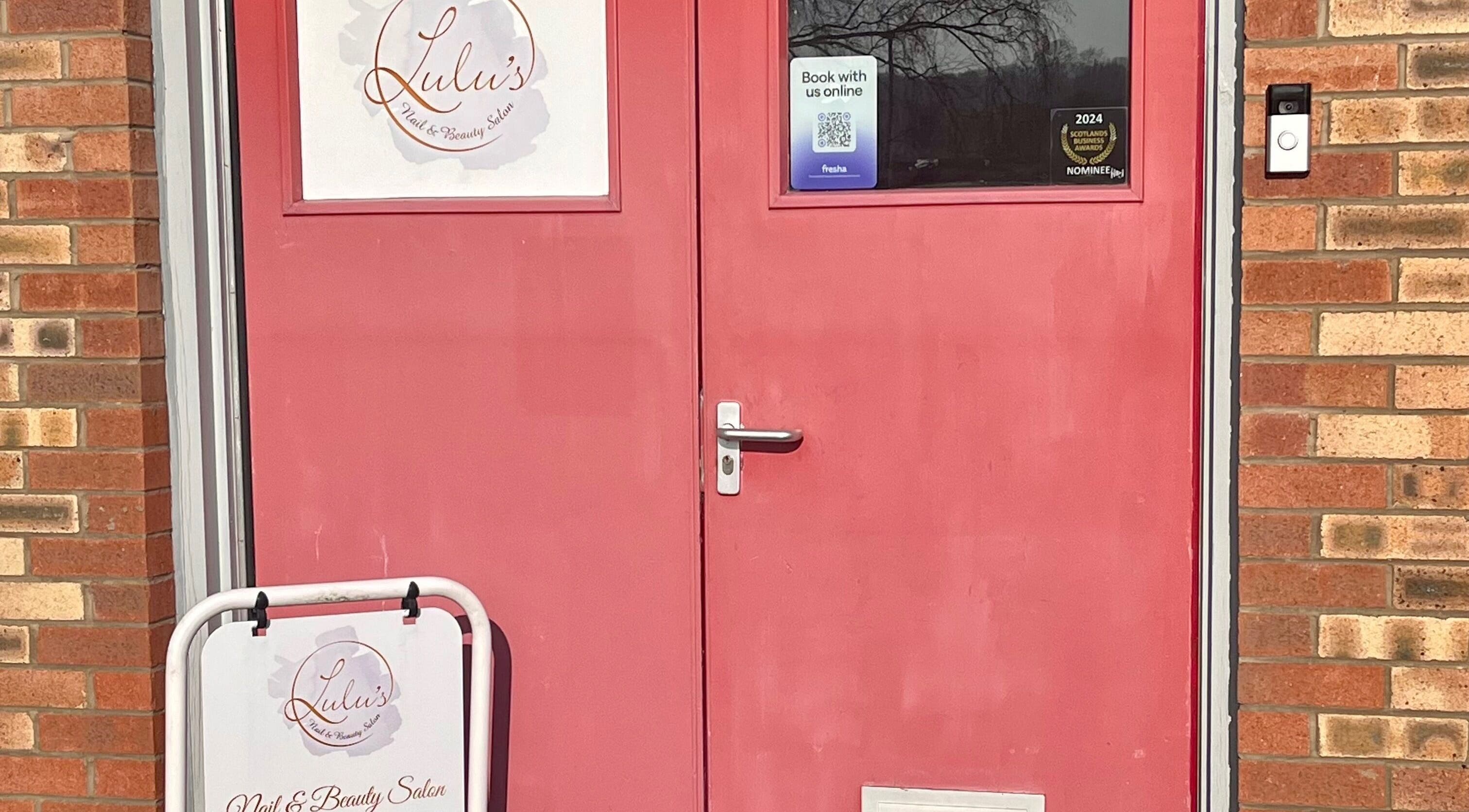 Red door entrance to LS Beauty and Massage in Linlithgow, Scotland, GB, with salon signage.