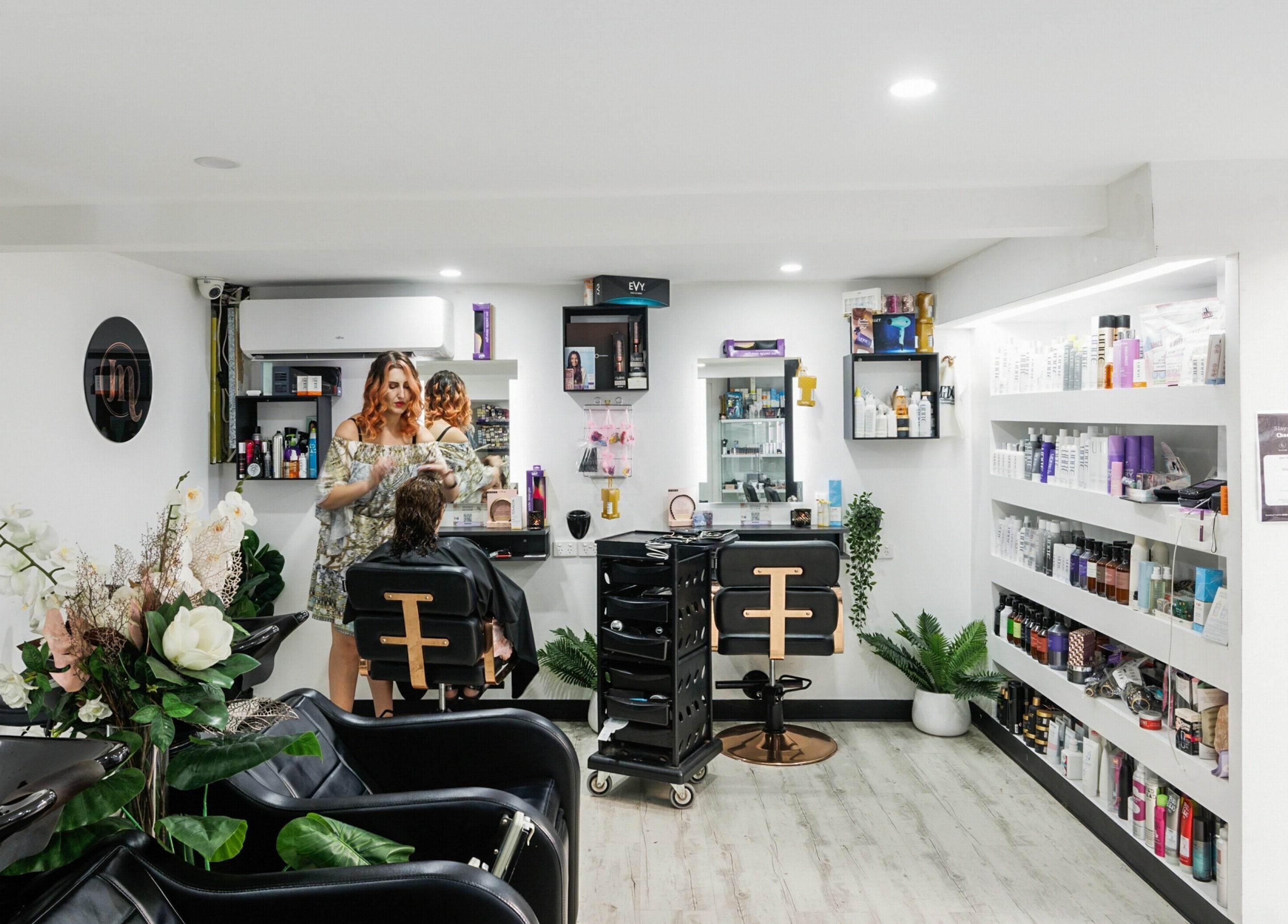 Stylish interior of Mane On Mowbray salon in East Brisbane, Queensland, AU featuring beauty products and a stylist at work.