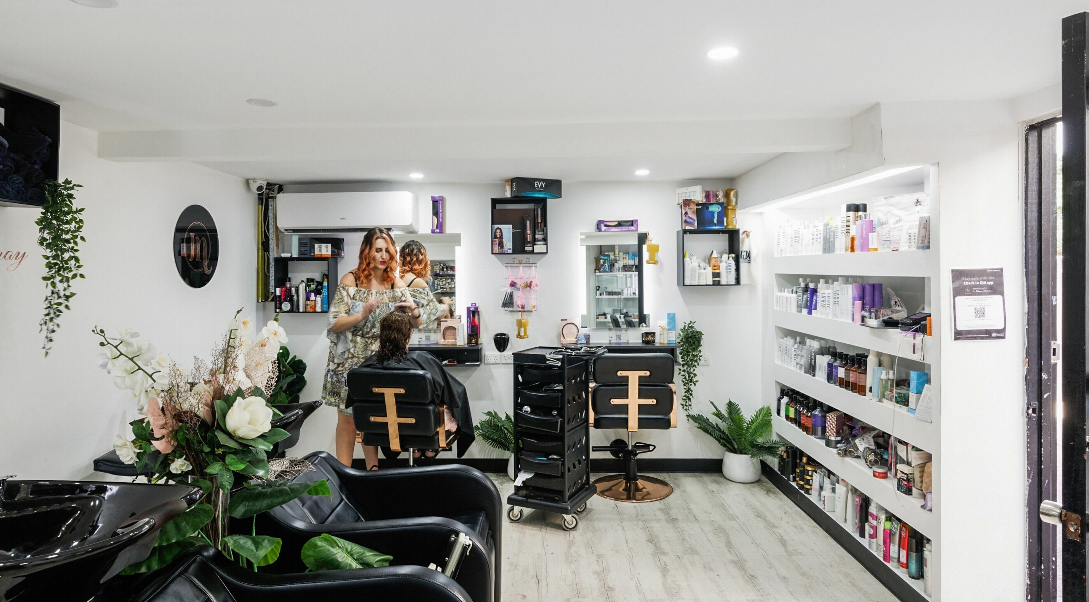 Stylish interior of Mane On Mowbray salon in East Brisbane, Queensland, AU featuring beauty products and a stylist at work.