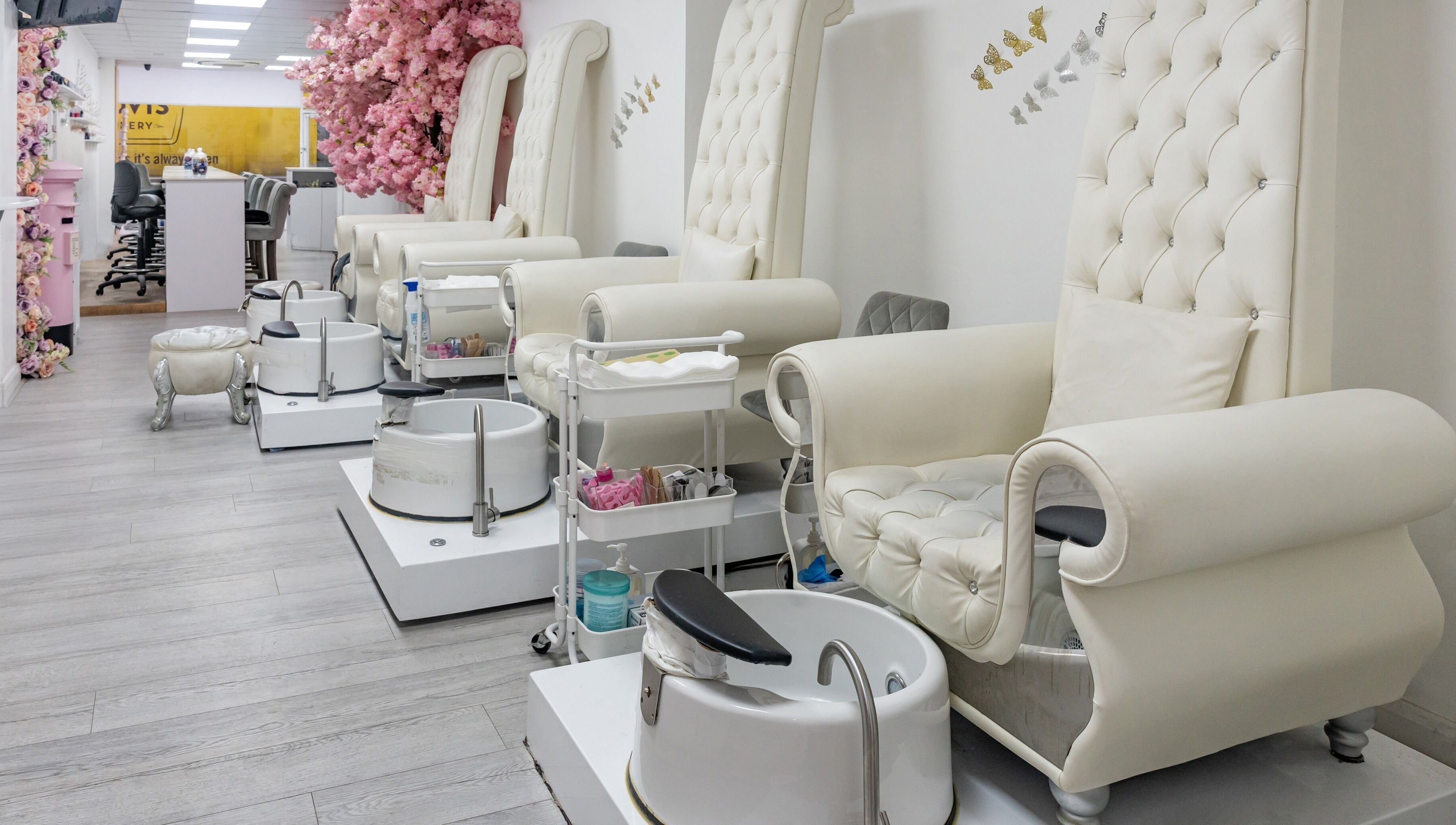 Elegant pedicure chairs at Chocolate & Nails - Ealing Broadway, London, England, GB, adorned with pink flowers.