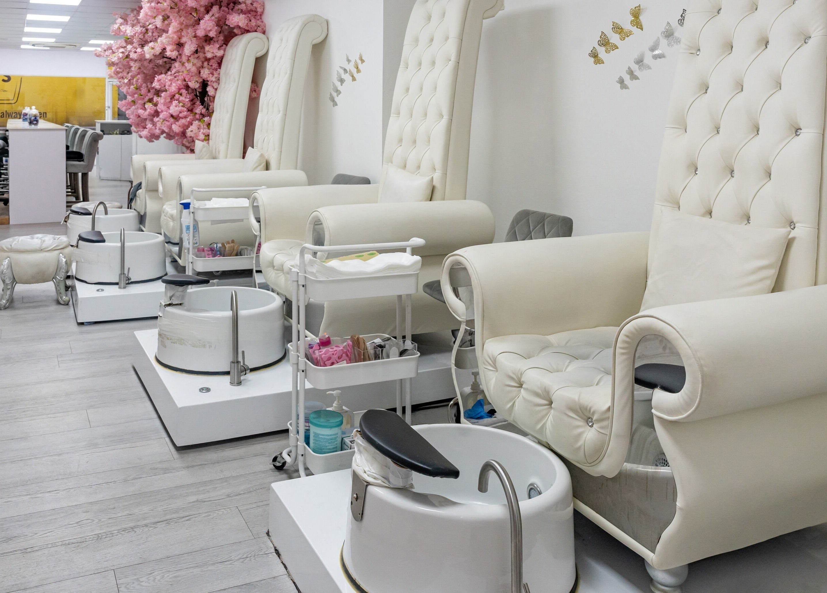 Elegant pedicure chairs at Chocolate & Nails - Ealing Broadway, London, England, GB, adorned with pink flowers.