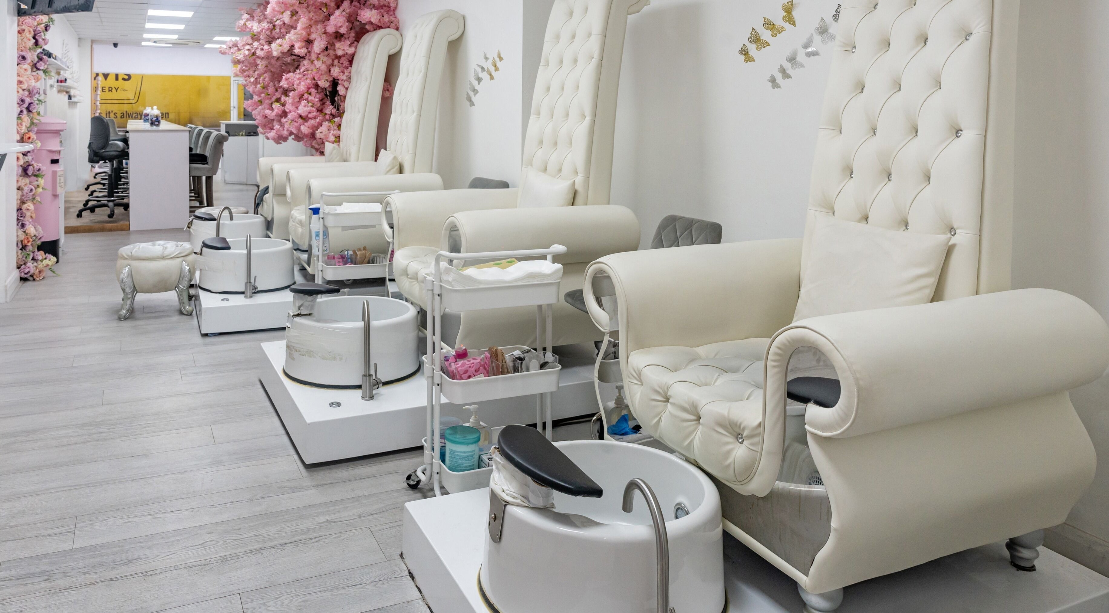 Elegant pedicure chairs at Chocolate & Nails - Ealing Broadway, London, England, GB, adorned with pink flowers.