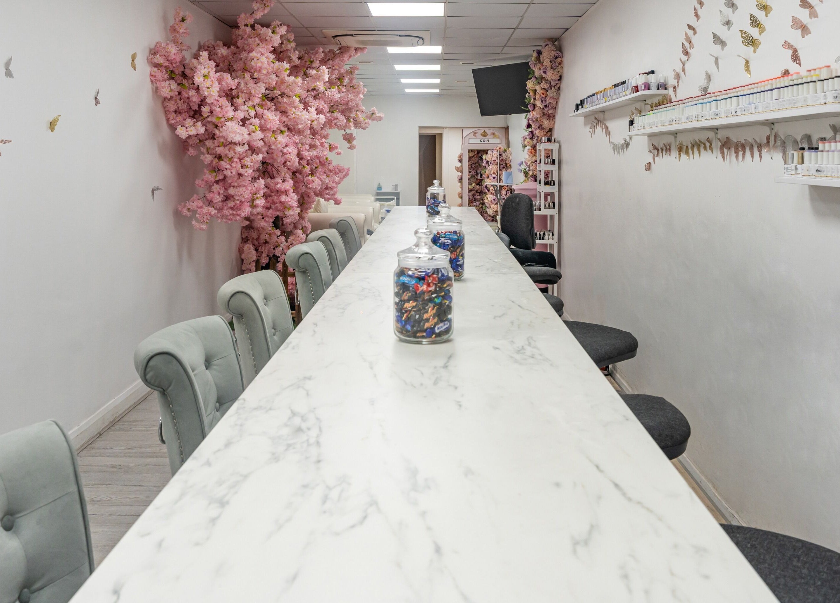 Chic interior of Chocolate & Nails - Ealing Broadway, London, with pink blossoms and spacious nail tables.