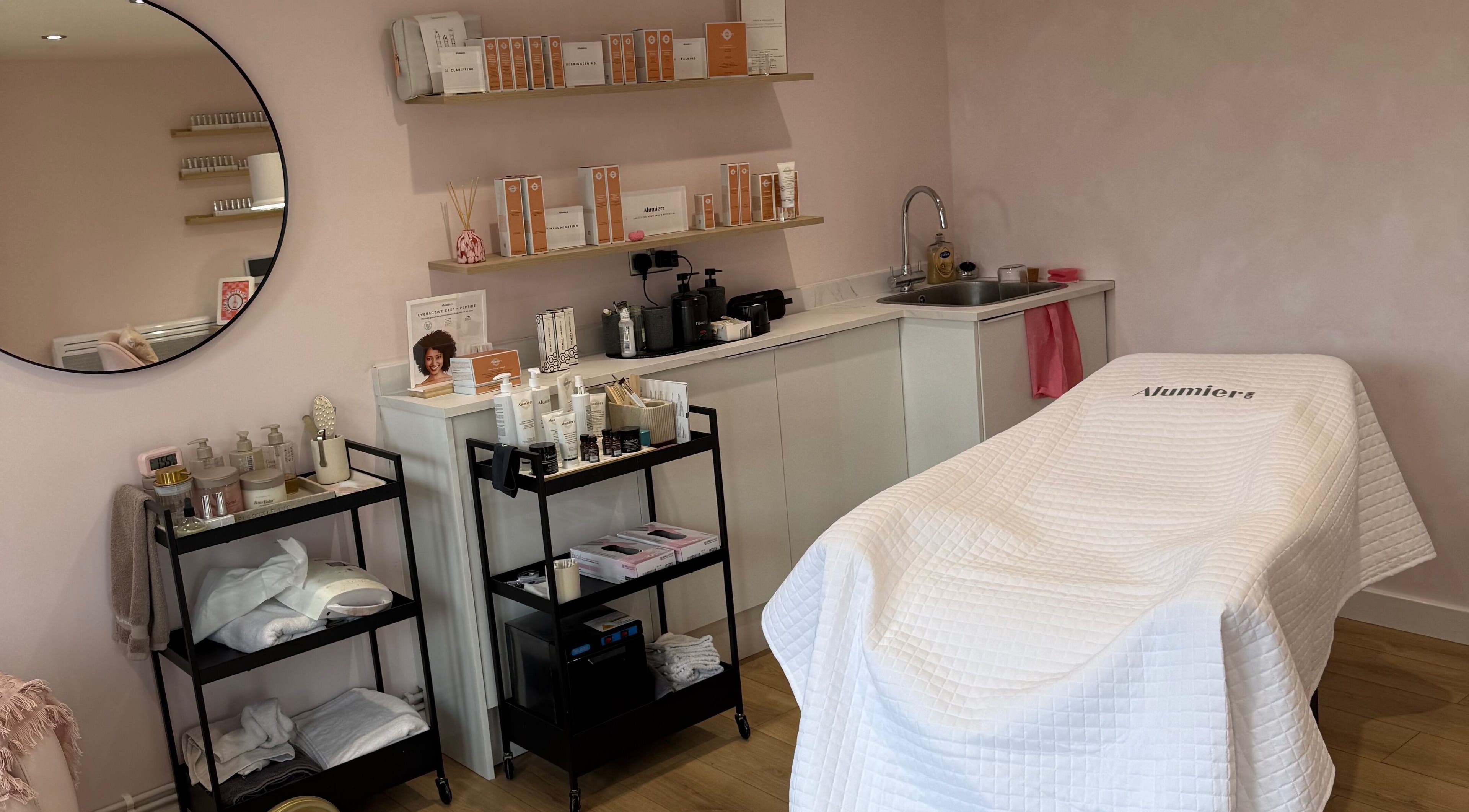 Calm treatment room at Pink Studios, Middlesbrough, England, GB, featuring spa essentials and comfortable therapy bed.