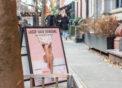 Sidewalk sign for laser hair removal at Écou's Laser Boutique, Scottsdale, Arizona, US, with stylish design.