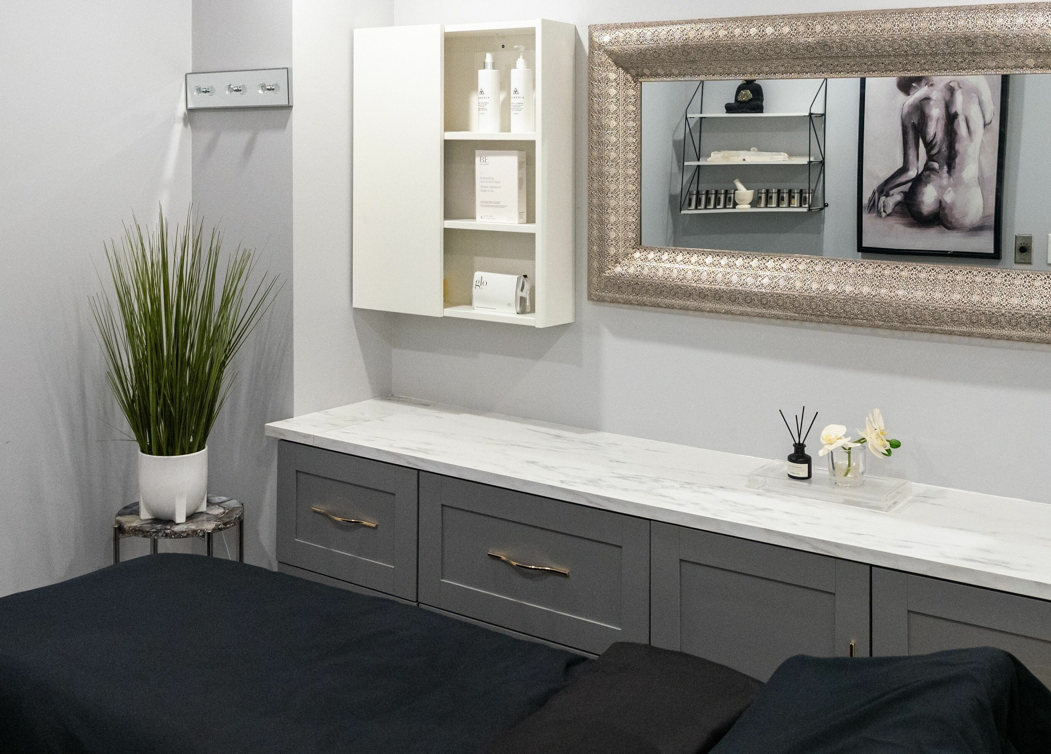 Elegant treatment room at Elysian Beauty Bar Inc, Windsor, Ontario, CA, featuring a chic mirror and modern decor.