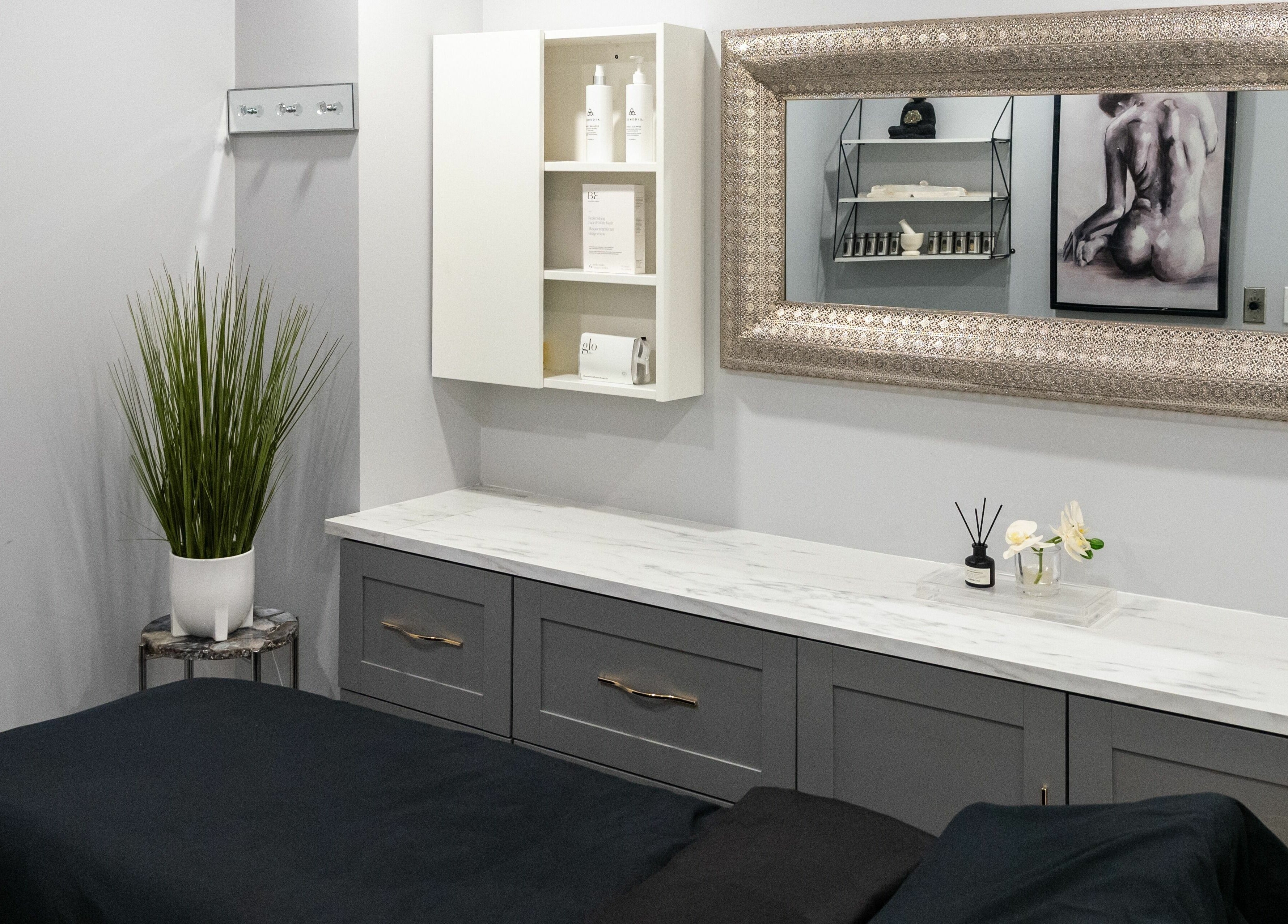 Elegant treatment room at Elysian Beauty Bar Inc, Windsor, Ontario, CA, featuring a chic mirror and modern decor.