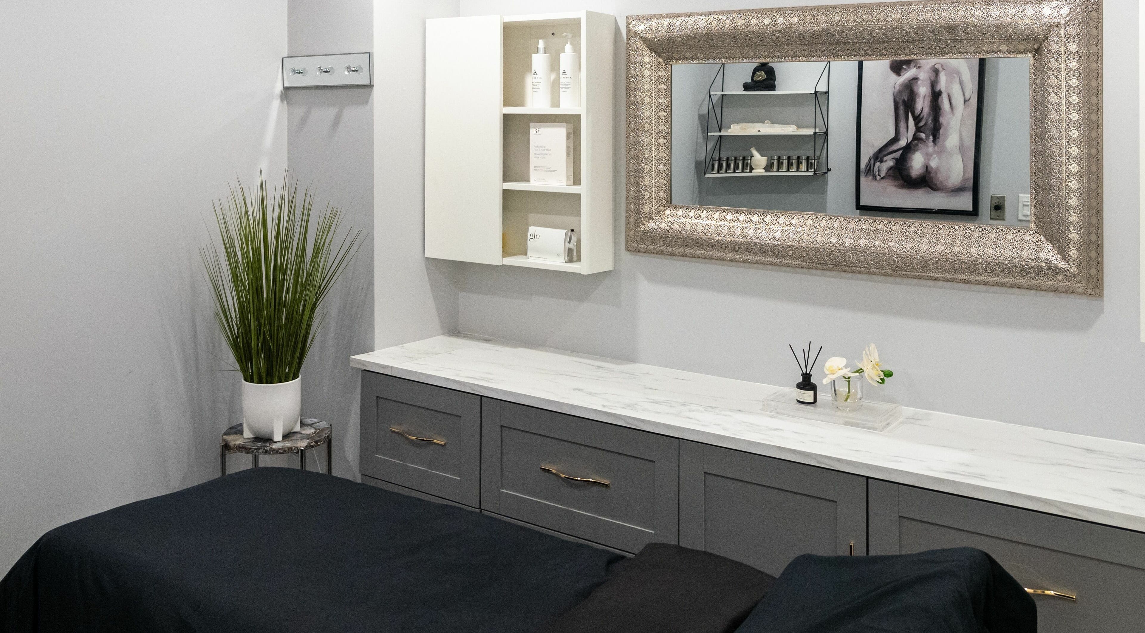 Elegant treatment room at Elysian Beauty Bar Inc, Windsor, Ontario, CA, featuring a chic mirror and modern decor.