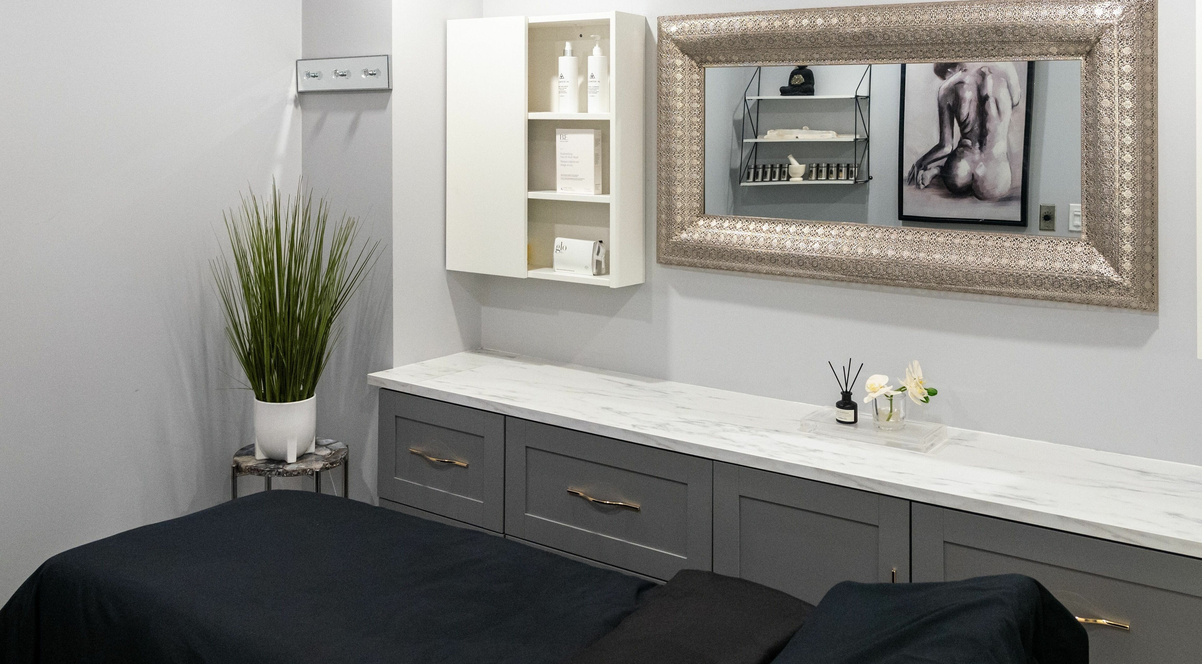 Elegant treatment room at Elysian Beauty Bar Inc, Windsor, Ontario, CA, featuring a chic mirror and modern decor.