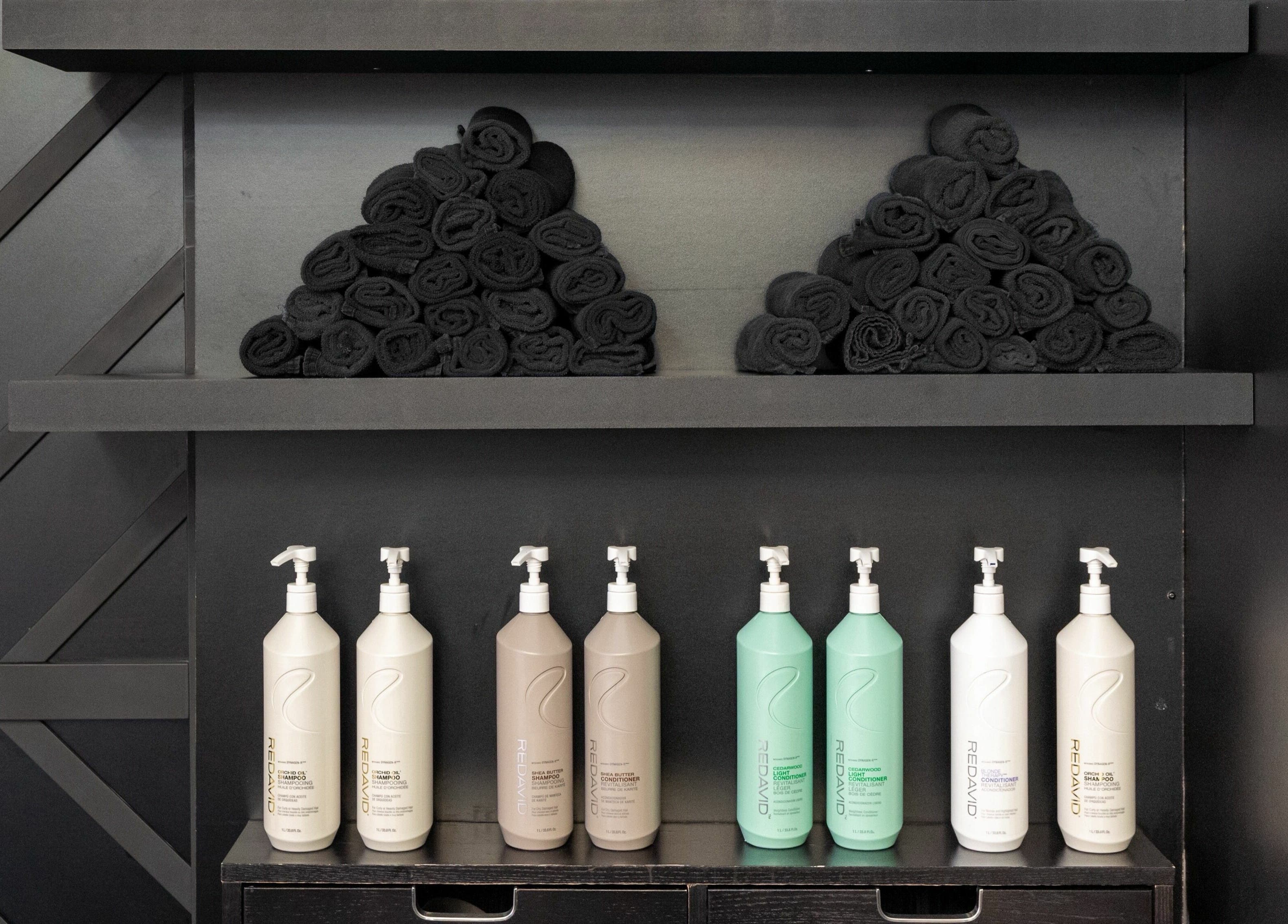 Elysian Beauty Bar Inc in Windsor, Ontario, CA features sleek shelves with neatly arranged towels and products.