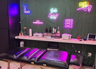 Inside Bai’s Beauty Room - Krum Clips Salon, Krum, Texas, US showcasing neon signs and a massage table.