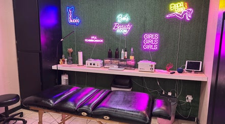 Inside Bai’s Beauty Room - Krum Clips Salon, Krum, Texas, US showcasing neon signs and a massage table.