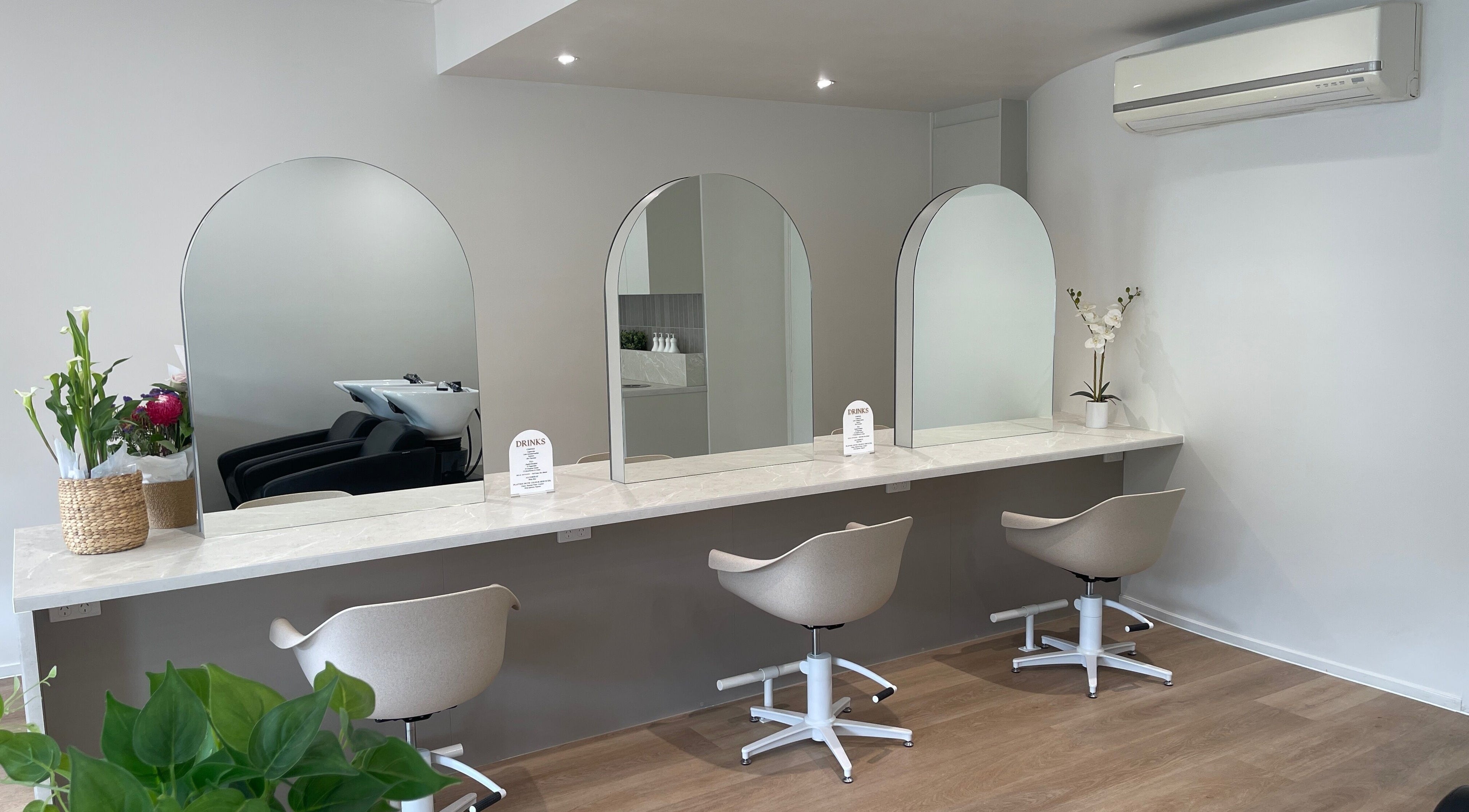 Elegant styling station at HBKR Boutique, Robina, Queensland, AU, featuring modern chairs and mirrors.