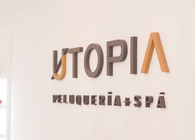Logotipo de Utopia Spa Pocitos en Montevideo, Departamento De Montevideo, UY, en una pared blanca.