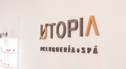Logotipo de Utopia Spa Pocitos en Montevideo, Departamento De Montevideo, UY, en una pared blanca.