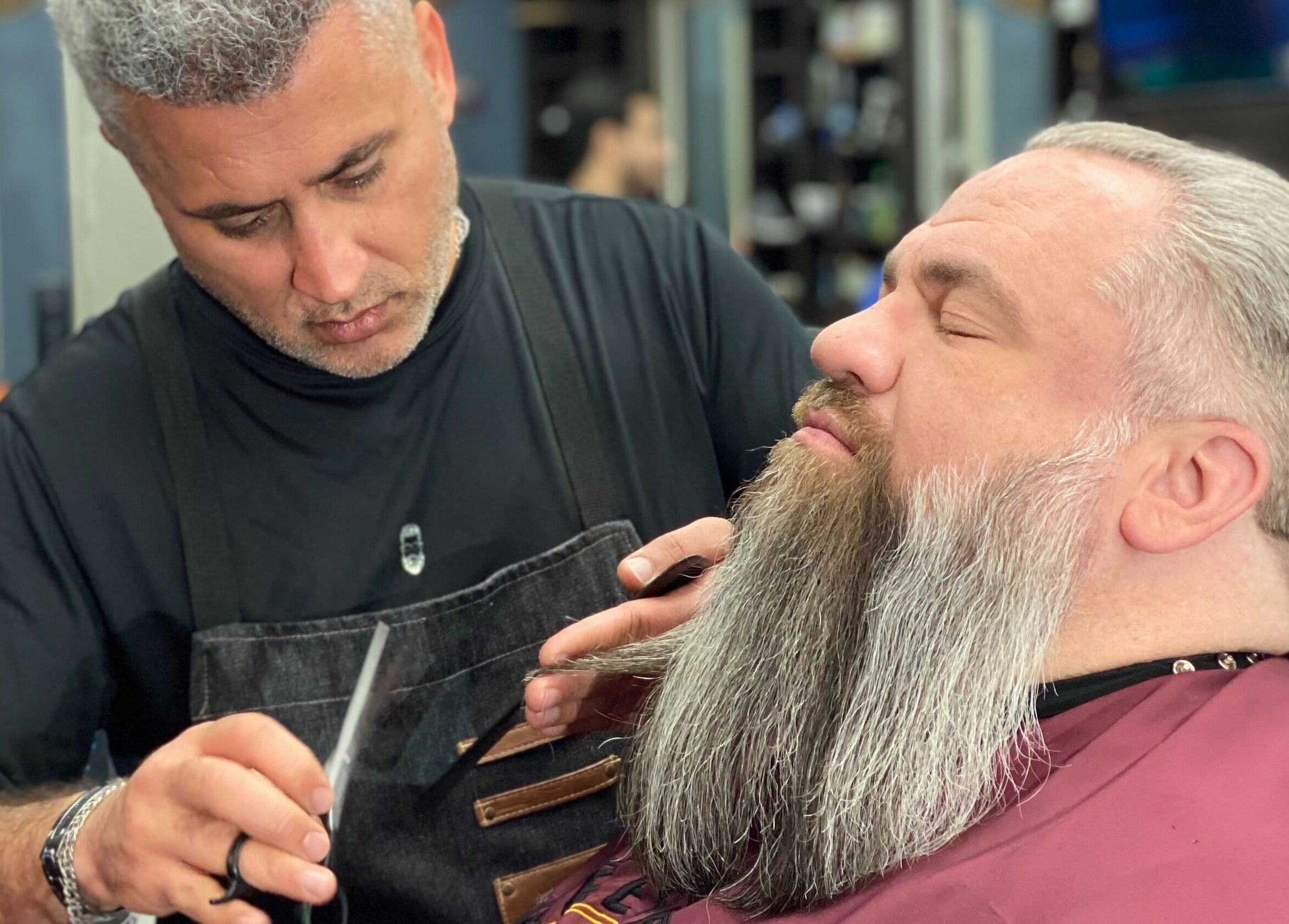 Barber expertly trims beard at Hardi Barbershop in Roswell, Georgia, US, creating a polished look.