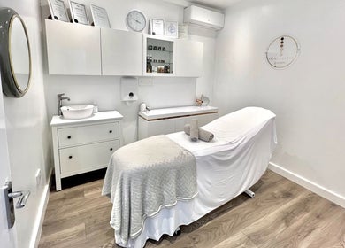 Cozy treatment room at N1 Beauty Base in London, England, GB, featuring a neutral palette and a therapy bed.