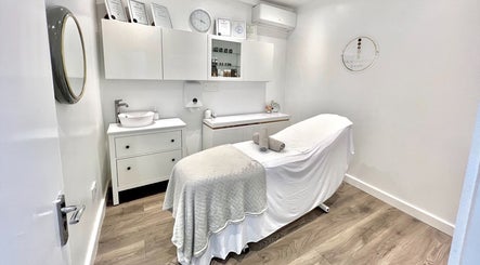Cozy treatment room at N1 Beauty Base in London, England, GB, featuring a neutral palette and a therapy bed.