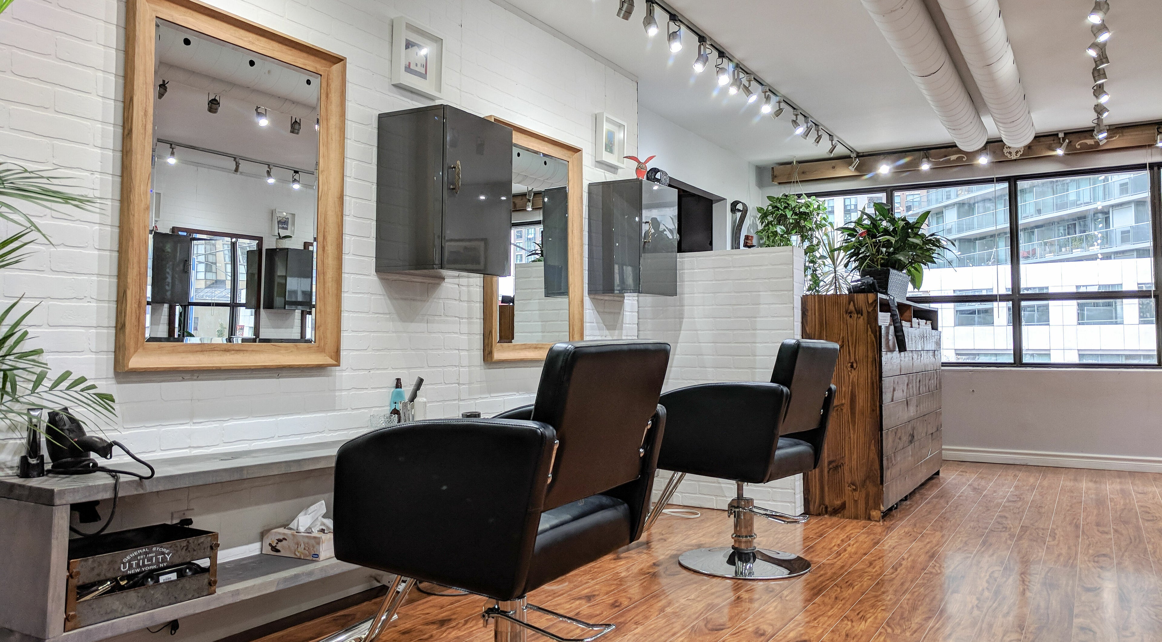 Interior of Balance Hair Studio in Toronto, Ontario, CA featuring stylish salon chairs and mirrors.