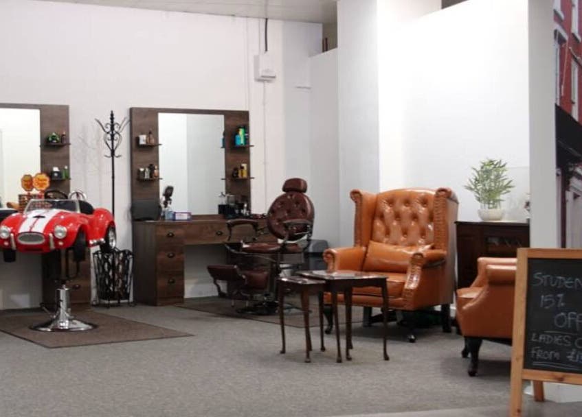 Interior of Darwin's Barbers in Shrewsbury, England, GB featuring chic seating and vintage decor.