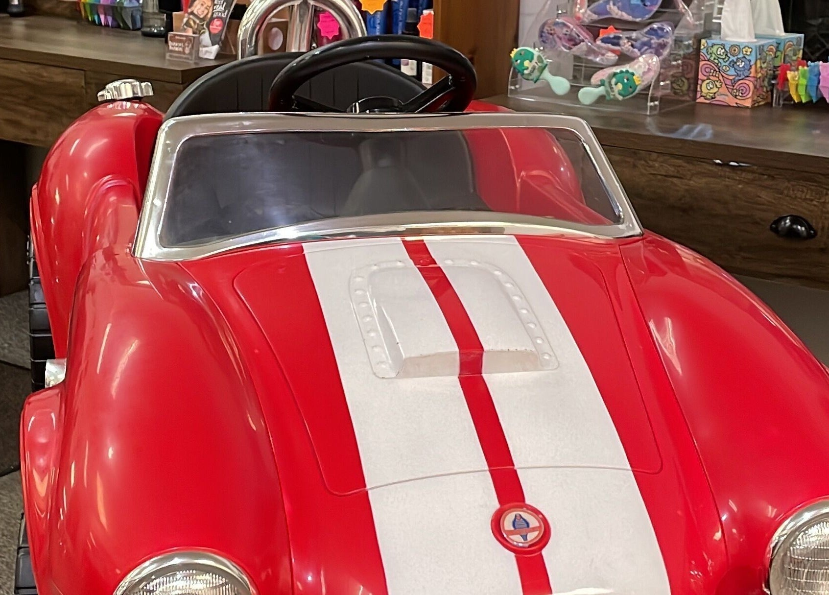 Red children's car chair in Darwin's Barbers, Shrewsbury, England, GB, creating a fun, engaging haircut experience.