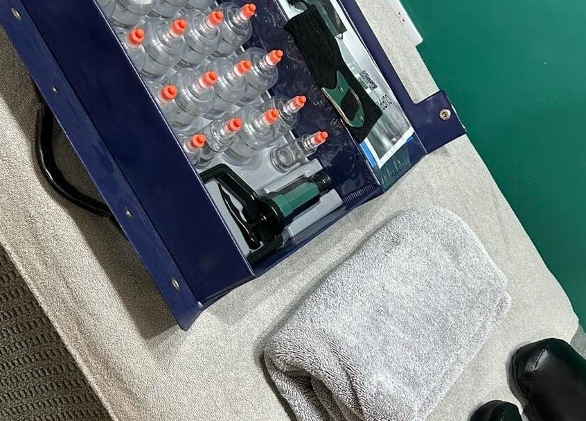 Cupping therapy set at Gn Fitness, Great Yarmouth, England, GB, including cups, pump, towel, and shoes.