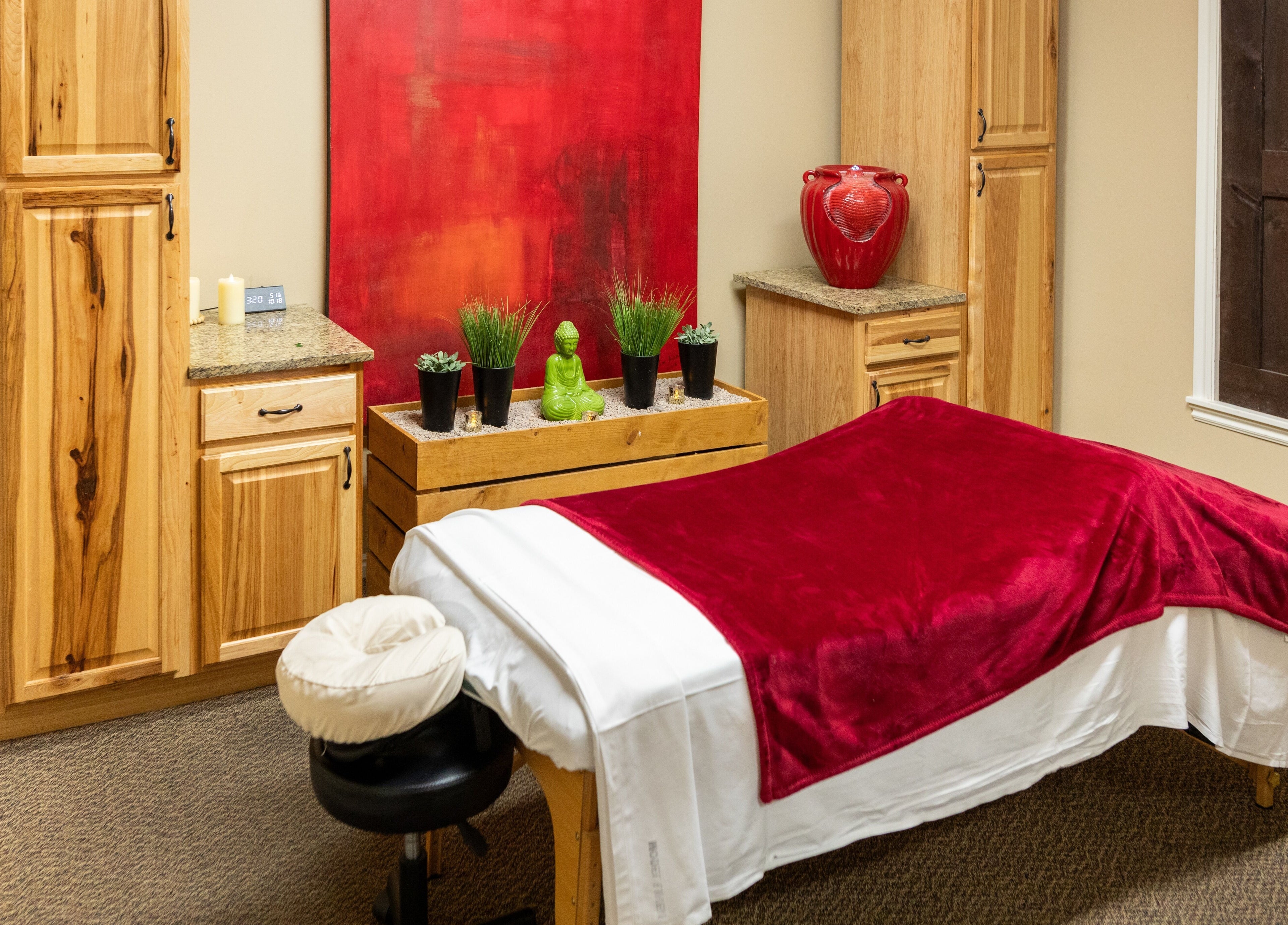 Massage room at Return To Harmony, Draper, Utah with red decor and relaxing ambiance.