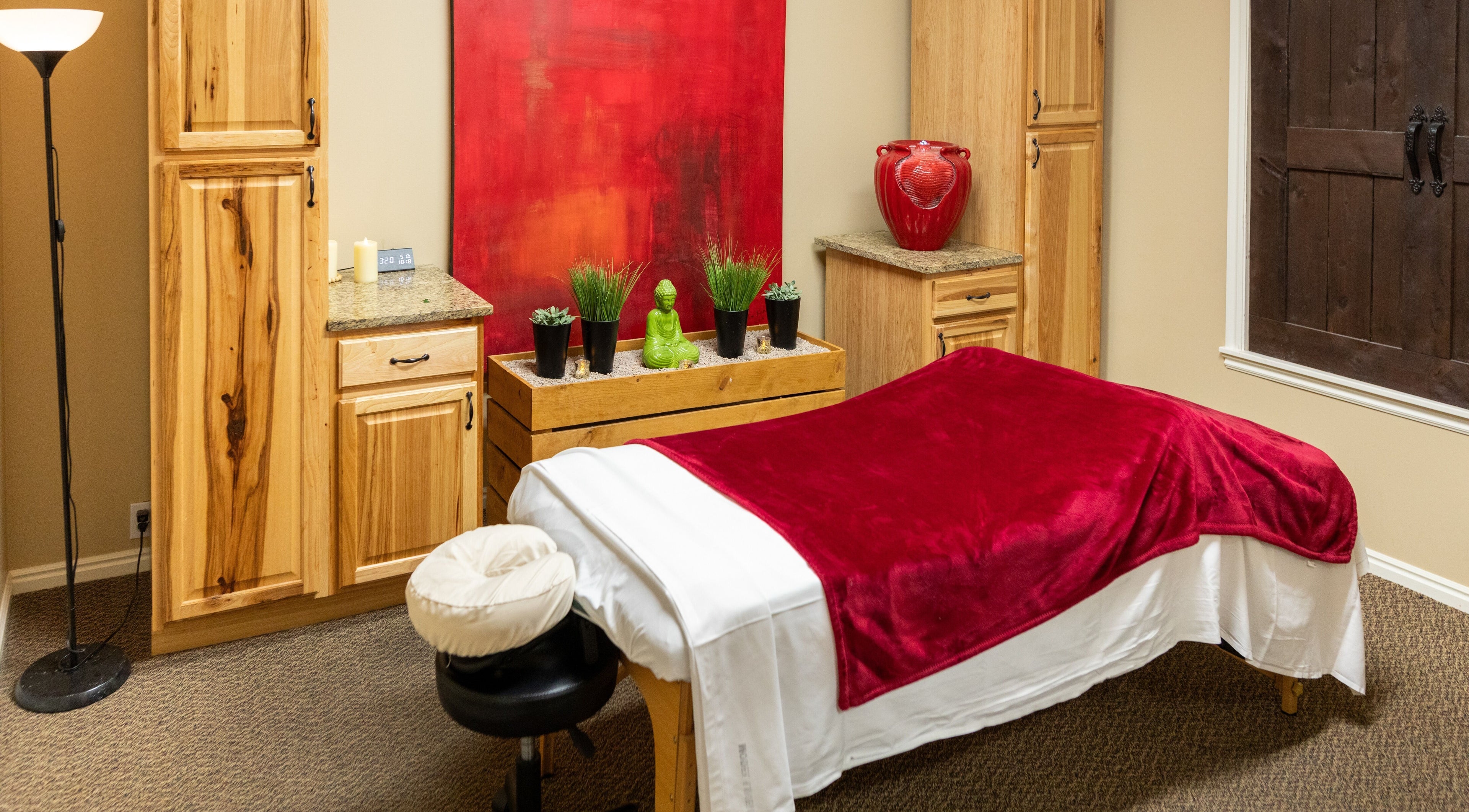 Massage room at Return To Harmony, Draper, Utah with red decor and relaxing ambiance.